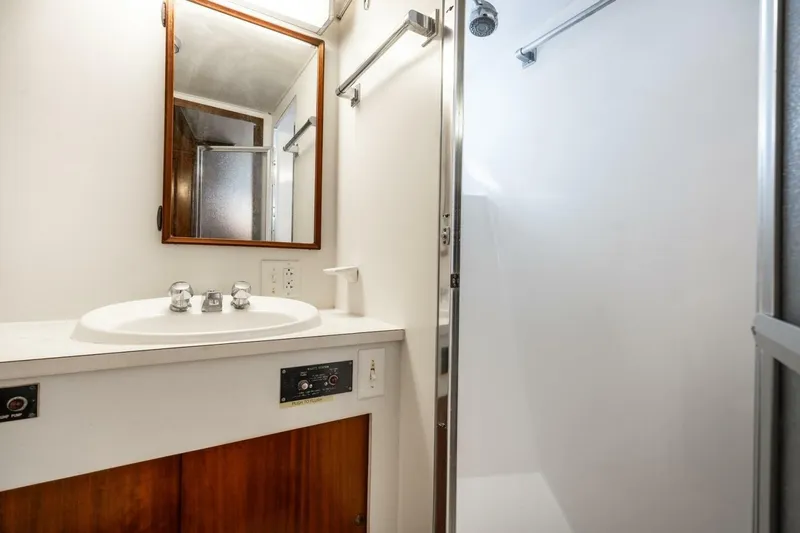 Slide: The Image of 1978 Hatteras 53 Yacht Fisherman bathroom with sink, mirror, and shower. - 59