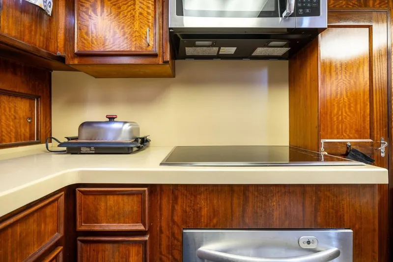 Slide: The Image of 1978 Hatteras 53 Yacht Fisherman kitchen with wooden cabinets and modern appliances. - 61