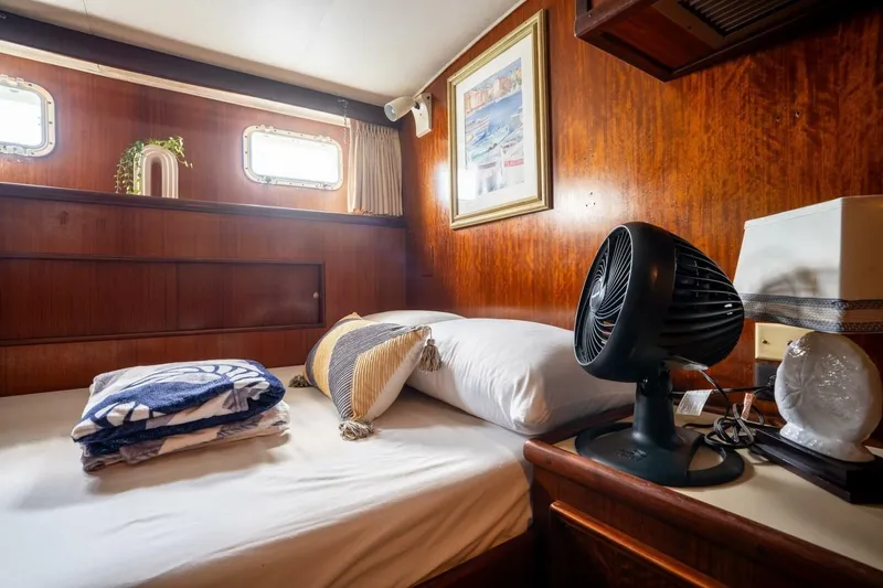 Slide: The Image of Cozy cabin interior of 1978 Hatteras 53 Yacht Fisherman with bed, fan, and decor. - 70