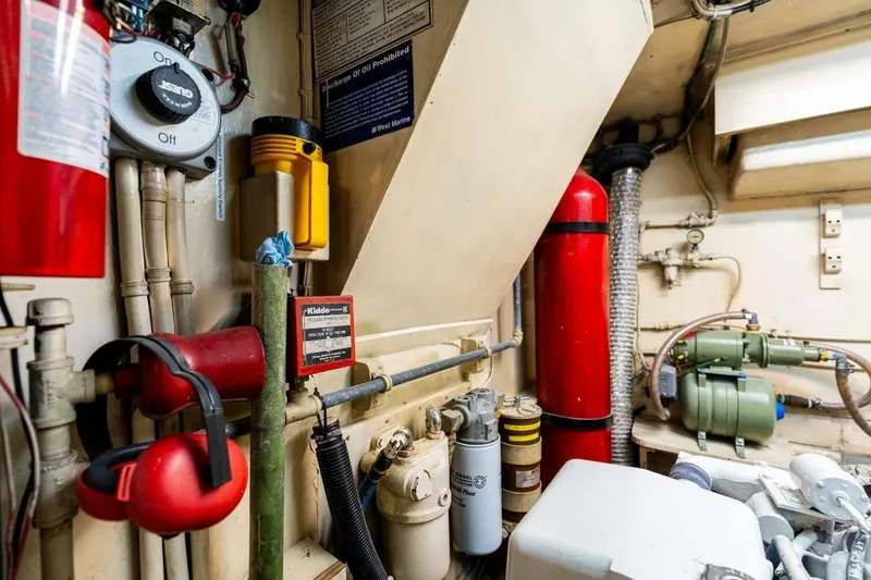 Slide: The Image of Engine room of a 1978 Hatteras 53 Yacht Fisherman with safety equipment and machinery. - 79