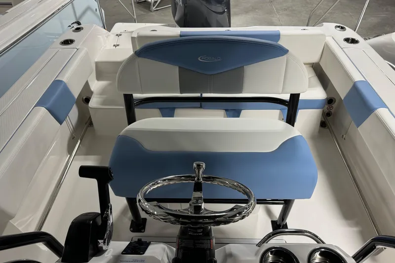 Slide: The Image of 2026 Robalo R202 Explorer boat interior with blue and white seating and steering wheel. - 7