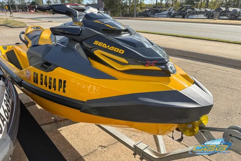 Slide: The Image of 2021 Sea-Doo RXT-X 300 jet ski in yellow, parked on a trailer. - 6