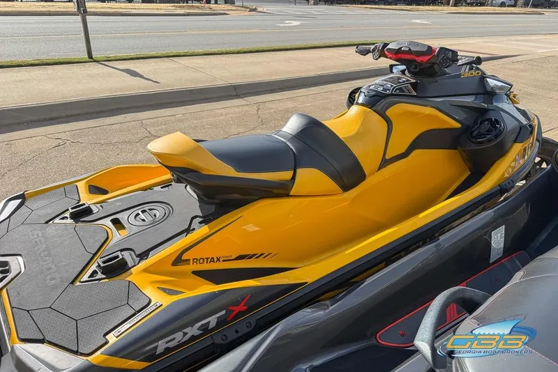 Slide: The Image of 2021 Sea-Doo RXT-X 300 jet ski, yellow and black, parked on pavement. - 7