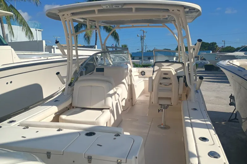 Slide: The Image of 2024 Grady-White Freedom 235 boat interior, featuring seating and helm, under a clear blue sky. - 1