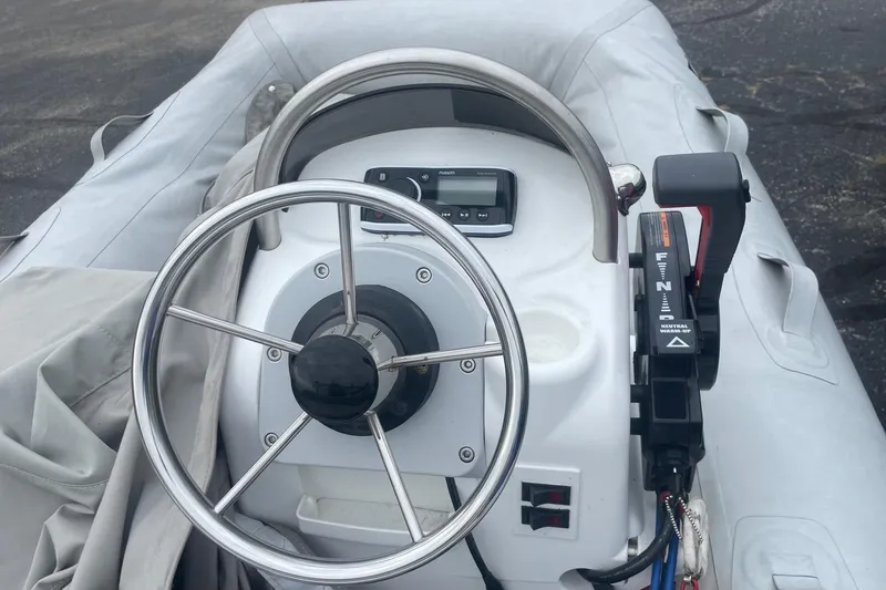 Slide: The Image of 2014 Walker Bay Odyssey 325 ST Console boat steering wheel and controls. - 3