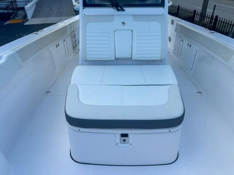 Slide: The Image of 2025 Edgewater 340CC boat interior with white seating and storage compartments. - 9