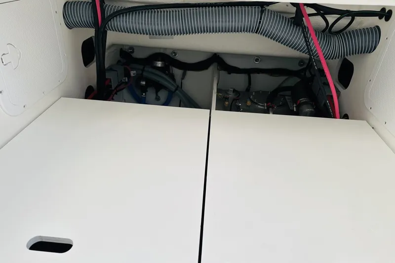 Slide: The Image of Engine compartment of 2026 Beneteau Antares 9 V2 with visible hoses and components. - 10