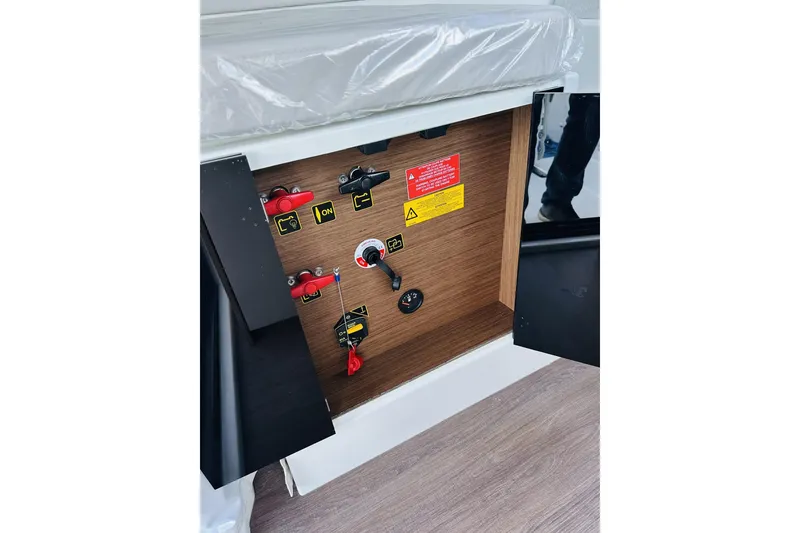 Slide: The Image of Electrical panel inside 2026 Beneteau Antares 9 V2 boat, featuring switches and safety labels. - 17