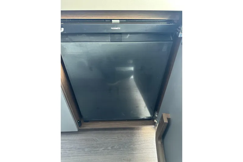 Slide: The Image of Refrigerator inside 2026 Beneteau Antares 9 V2 boat, featuring a sleek black design. - 18