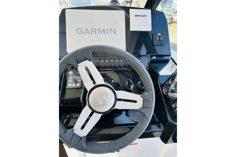 Slide: The Image of Steering wheel and dashboard of 2026 Beneteau Antares 9 V2 with Garmin and Mercury controls. - 24