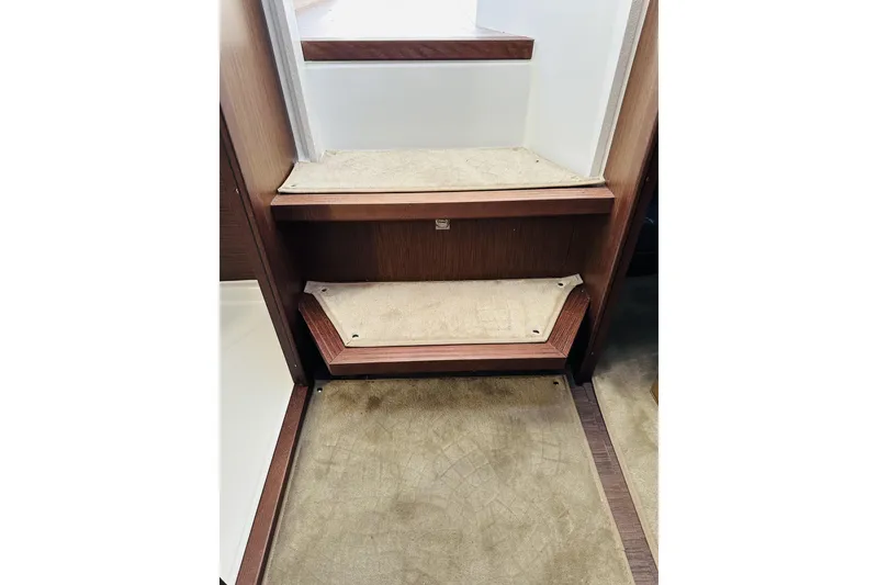 Slide: The Image of Interior steps of 2026 Beneteau Antares 9 V2, featuring wood and carpet design. - 32