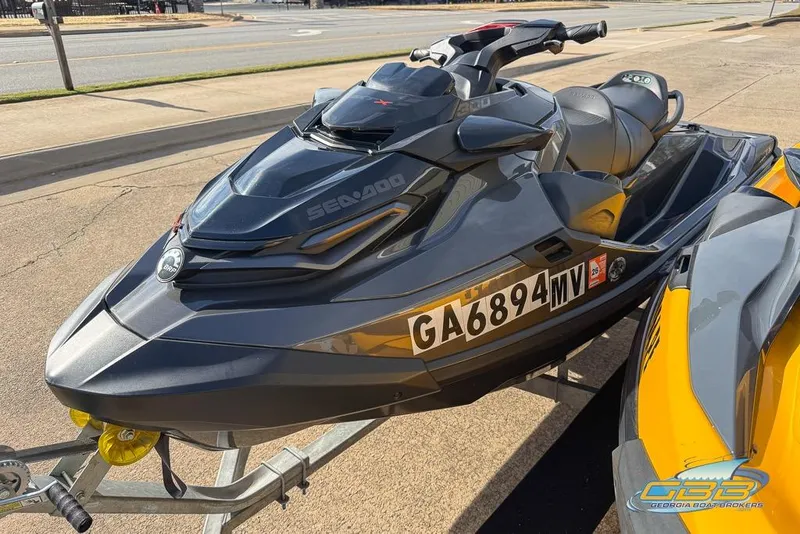 Slide: The Image of 2023 Sea-Doo RXT-X 300 jet ski on trailer, parked on pavement. - 7