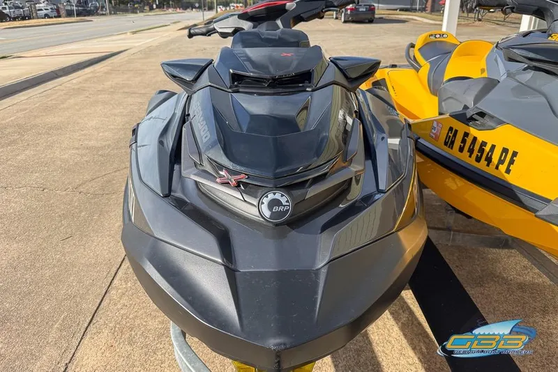 Slide: The Image of 2023 Sea-Doo RXT-X 300 jet ski in black, parked on pavement. - 8