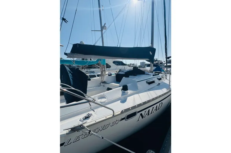 Slide: The Image of 1989 Hunter Legend 37 sailboat docked in a marina, surrounded by other boats. - 13