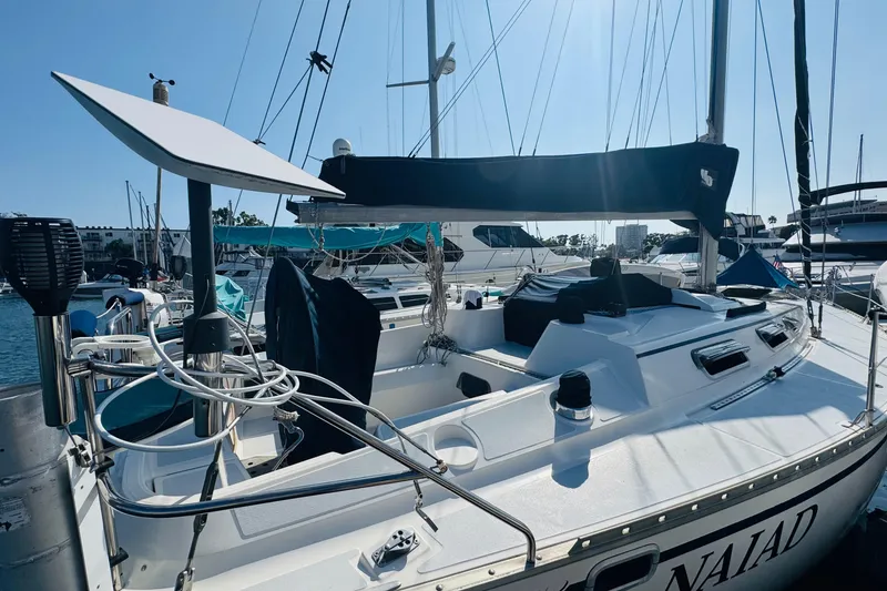 Slide: The Image of 1989 Hunter Legend 37 sailboat docked in a marina, featuring a spacious cockpit. - 14