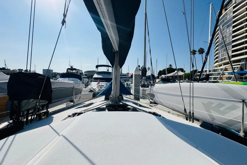 Slide: The Image of 1989 Hunter Legend 37 sailboat docked in a marina, showcasing sleek design and rigging. - 15