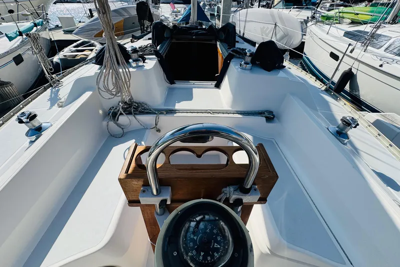 Slide: The Image of Sailboat docked in marina, Hunter Legend 37, 1989, surrounded by yachts and palm trees. - 19