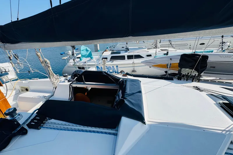 Slide: The Image of Sailboat Hunter Legend 37, 1989 model, docked in a marina under clear blue sky. - 28