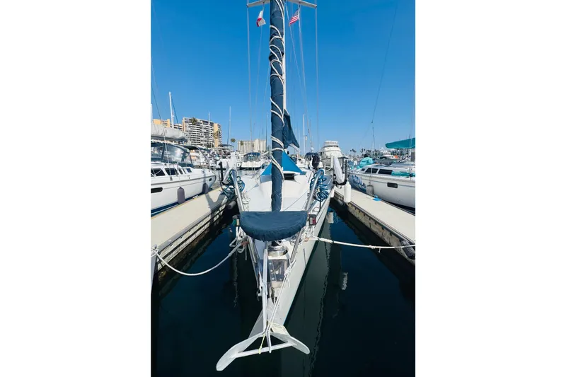 Slide: The Image of Sailboat Hunter Legend 37, 1990 model, anchored near a rocky coastline. - 3