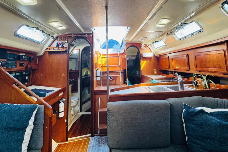 Slide: The Image of 1989 Hunter Legend 37 sailboat docked at marina, featuring blue canvas cover. - 34