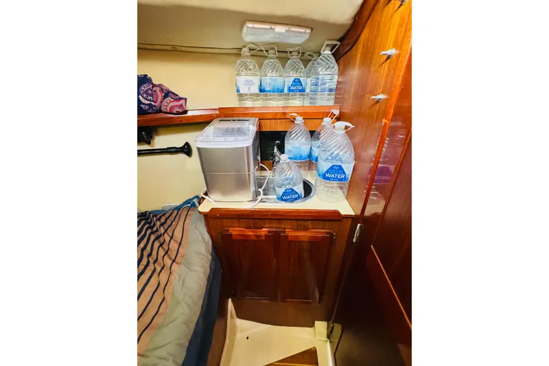 Slide: The Image of Interior of 1989 Hunter Legend 37 sailboat with wooden cabinets and teal bedding. - 57