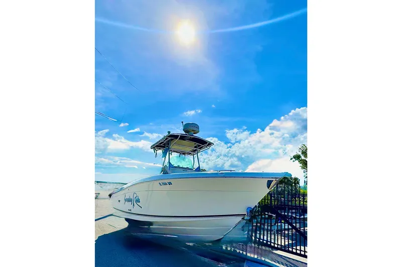 Slide: The Image of 2004 Robalo R260 Center Console boat with dual Yamaha engines, docked in a parking area. - 26
