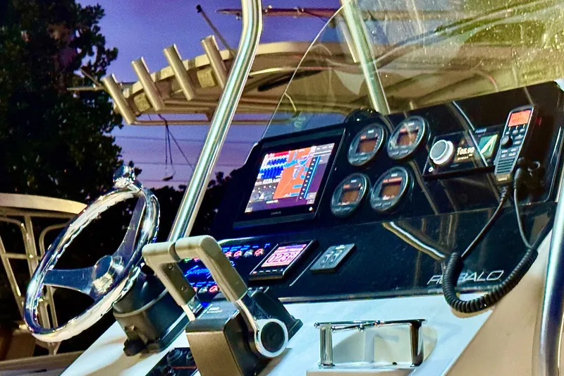 Slide: The Image of 2004 Robalo R260 Center Console boat at sunset, surrounded by other boats. - 3