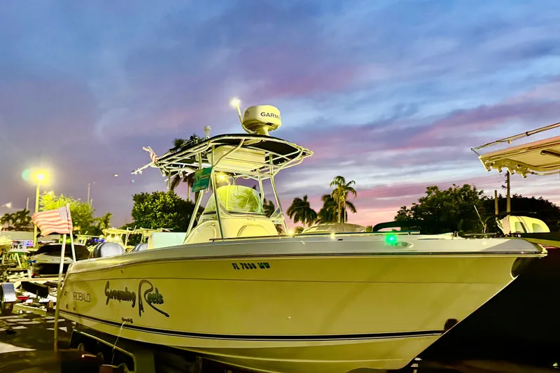 Slide: The Image of 2004 Robalo R260 Center Console boat dashboard with steering wheel and controls. - 32