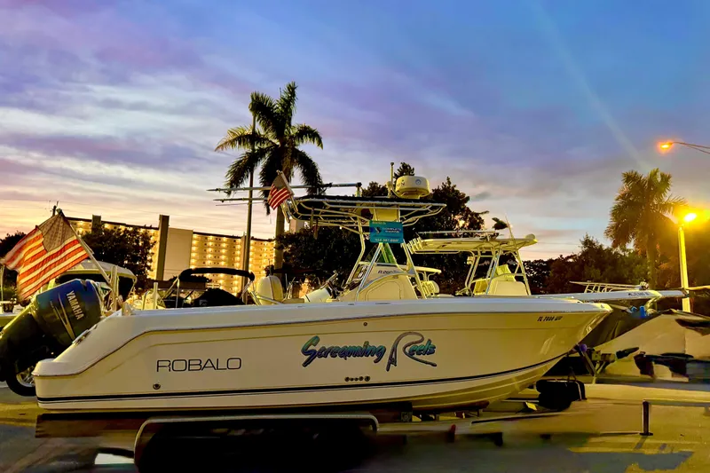 Slide: The Image of Yamaha outboard motor on 2004 Robalo R260 Center Console boat, parked outdoors. - 4