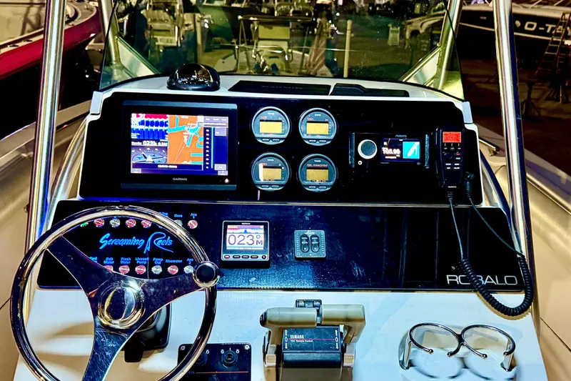 Slide: The Image of 2004 Robalo R260 Center Console boat with dual outboard motors in a marina setting. - 5