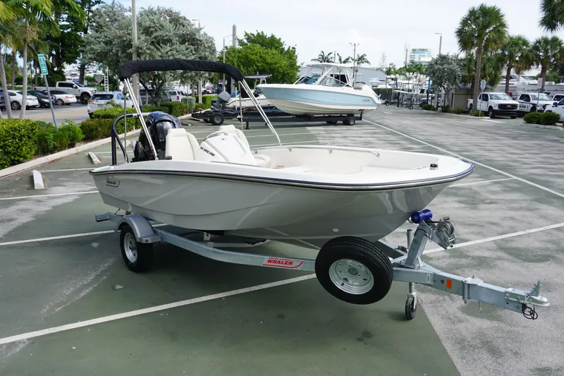 Slide: The Image of 2026 Boston Whaler 160 Super Sport boat on trailer in parking lot. - 3