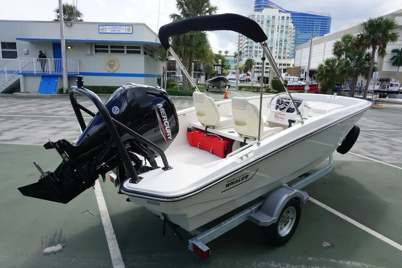 Slide: The Image of 2026 Boston Whaler 160 Super Sport boat on trailer, parked near marina. - 4
