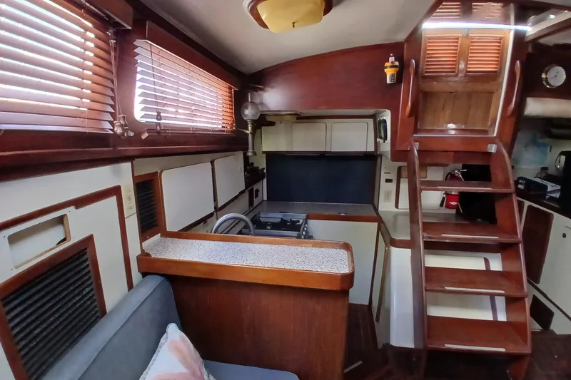 Slide: The Image of Interior of 1986 Irwin 43 sailboat with wooden cabinetry and compact kitchen area. - 12