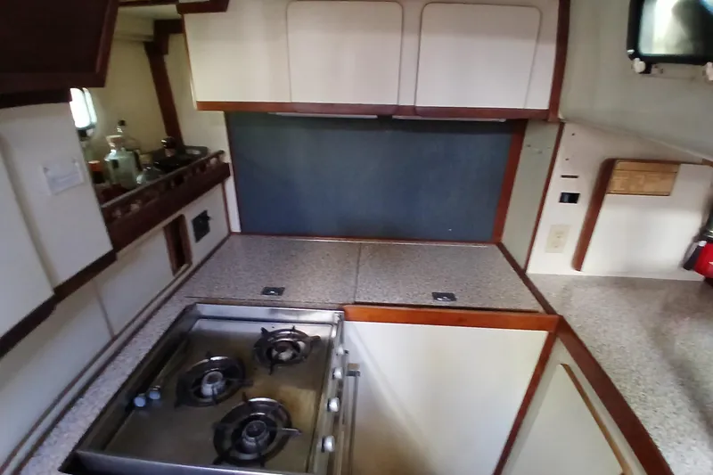 Slide: The Image of 1986 Irwin 43 yacht kitchen with stove, cabinets, and countertop. - 15