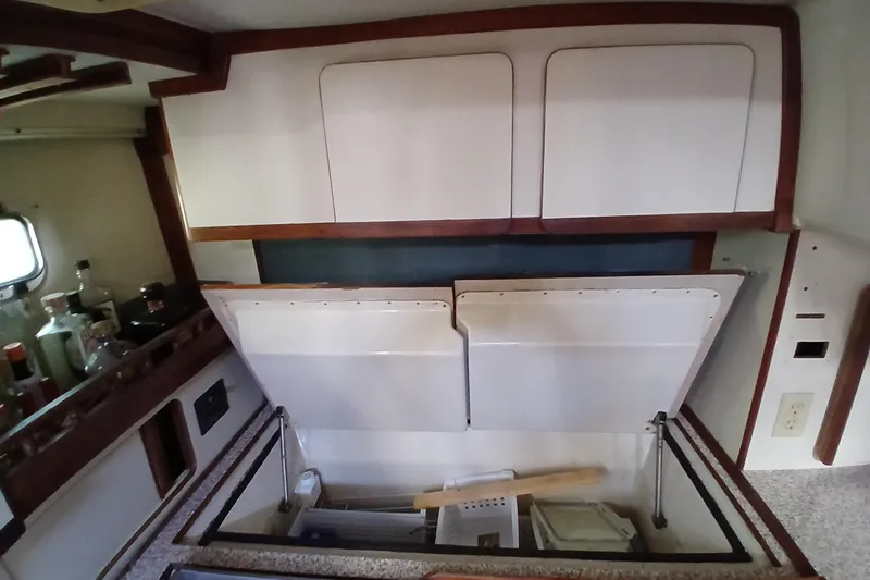 Slide: The Image of 1986 Irwin 43 yacht kitchen with open cabinets and countertop storage. - 17