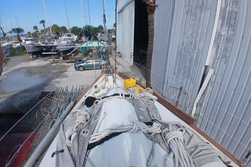 Slide: The Image of 1986 Irwin 43 sailboat in a boatyard with ropes and equipment. - 23