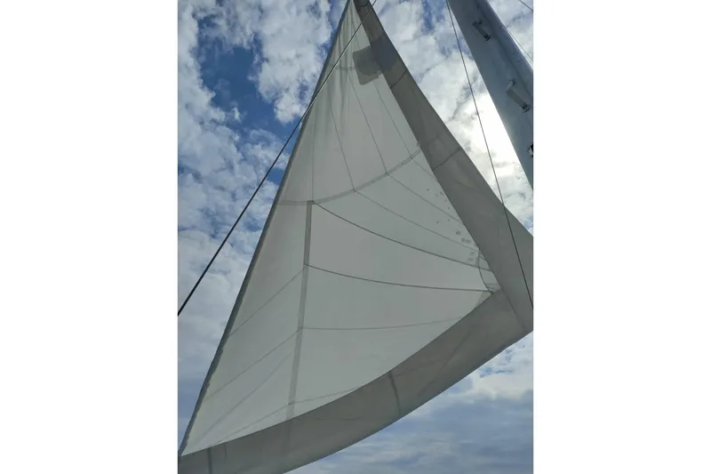 Slide: The Image of Sail of 1986 Irwin 43 yacht against a cloudy blue sky. - 27