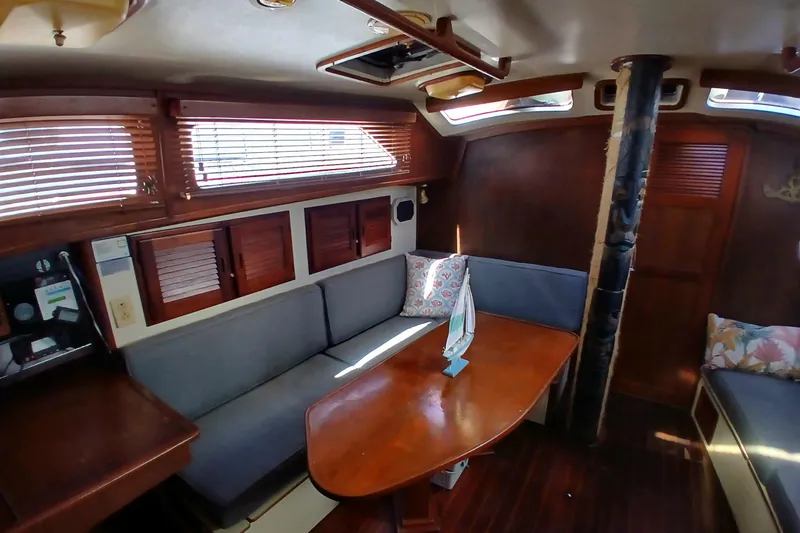 Slide: The Image of Interior of a 1986 Irwin 43 sailboat with wooden furnishings and cozy seating area. - 7