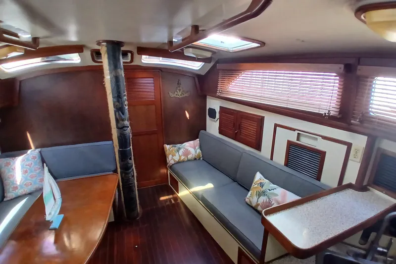 Slide: The Image of 1986 Irwin 43 yacht interior with wooden decor, cushioned seating, and natural light. - 8