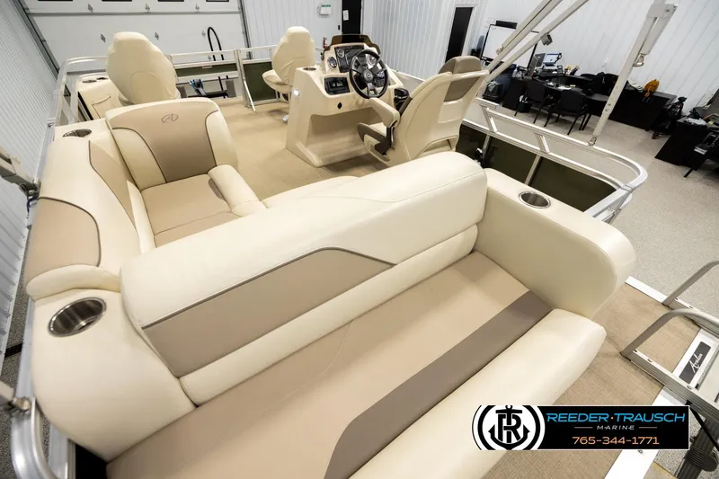 Slide: The Image of 2023 Avalon VEN BF boat interior with beige seating and modern helm in showroom. - 11