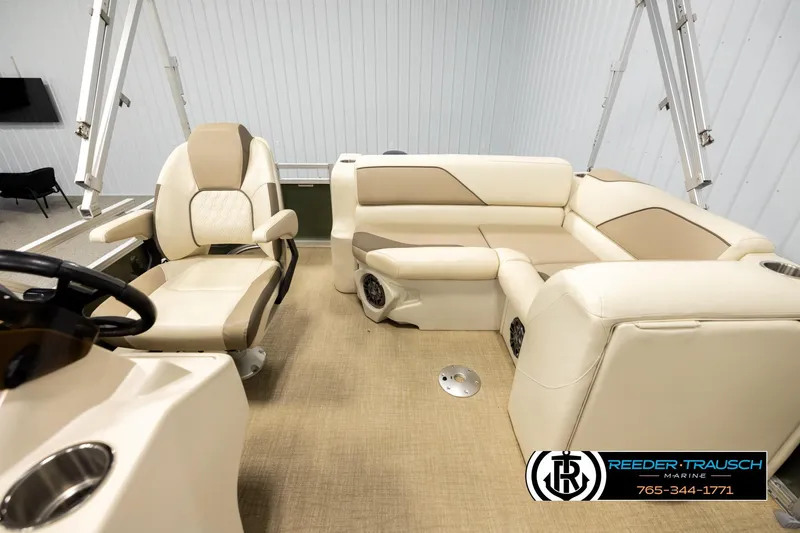 Slide: The Image of 2023 Avalon VEN BF boat interior with beige seating and steering console. - 14