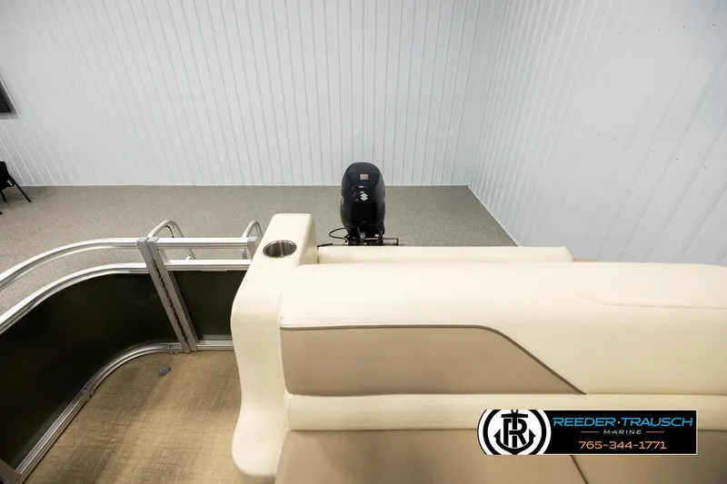 Slide: The Image of 2023 Avalon VEN BF boat interior with beige seating and motor, displayed indoors. - 15