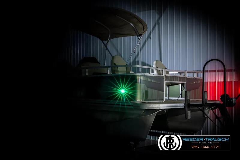 Slide: The Image of 2023 Avalon VEN BF pontoon boat with green navigation light in a dimly lit setting. - 4