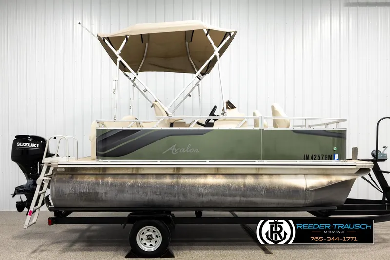 Slide: The Image of 2023 Avalon VEN BF pontoon boat with Suzuki motor and canopy, displayed indoors. - 5