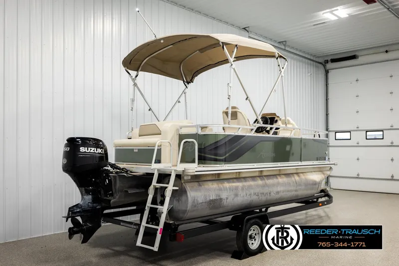 Slide: The Image of 2023 Avalon VEN BF pontoon boat with Suzuki engine in a garage setting. - 6