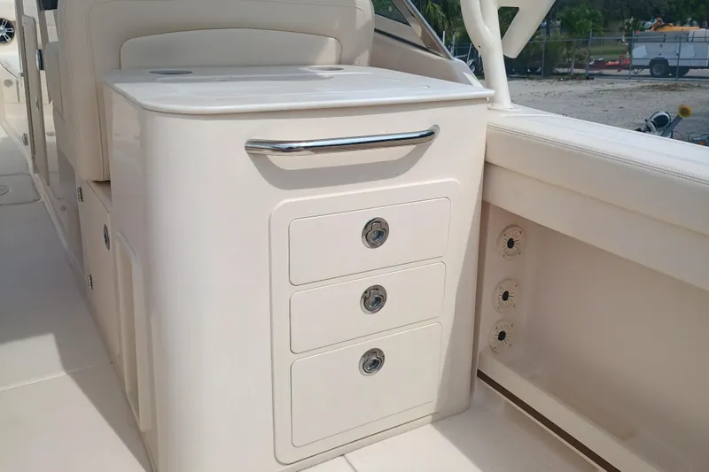 Slide: The Image of 2025 Grady-White Freedom 275 boat interior with storage drawers and seating area. - 10