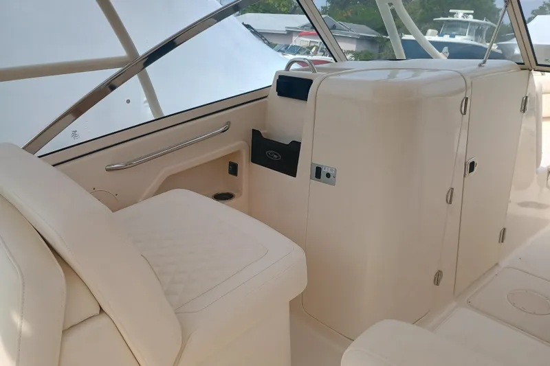 Slide: The Image of 2025 Grady-White Freedom 275 boat interior with beige seating and storage compartments. - 12