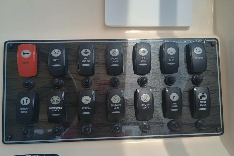Slide: The Image of Control panel of a 2025 Grady-White Freedom 275 boat with labeled switches. - 17