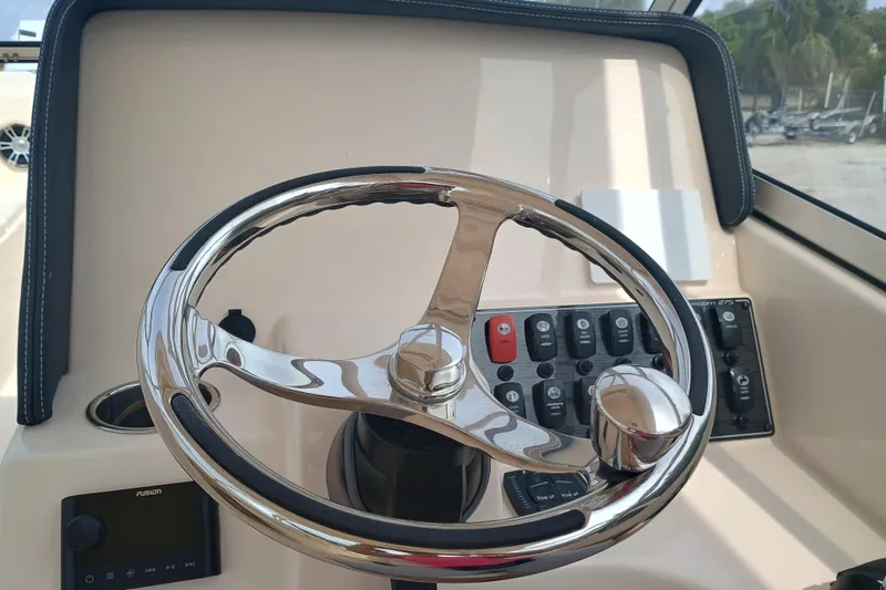 Slide: The Image of 2025 Grady-White Freedom 275 boat steering wheel and control panel. - 19