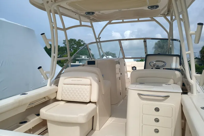 Slide: The Image of 2025 Grady-White Freedom 275 boat interior with seating and helm, under a clear sky. - 6
